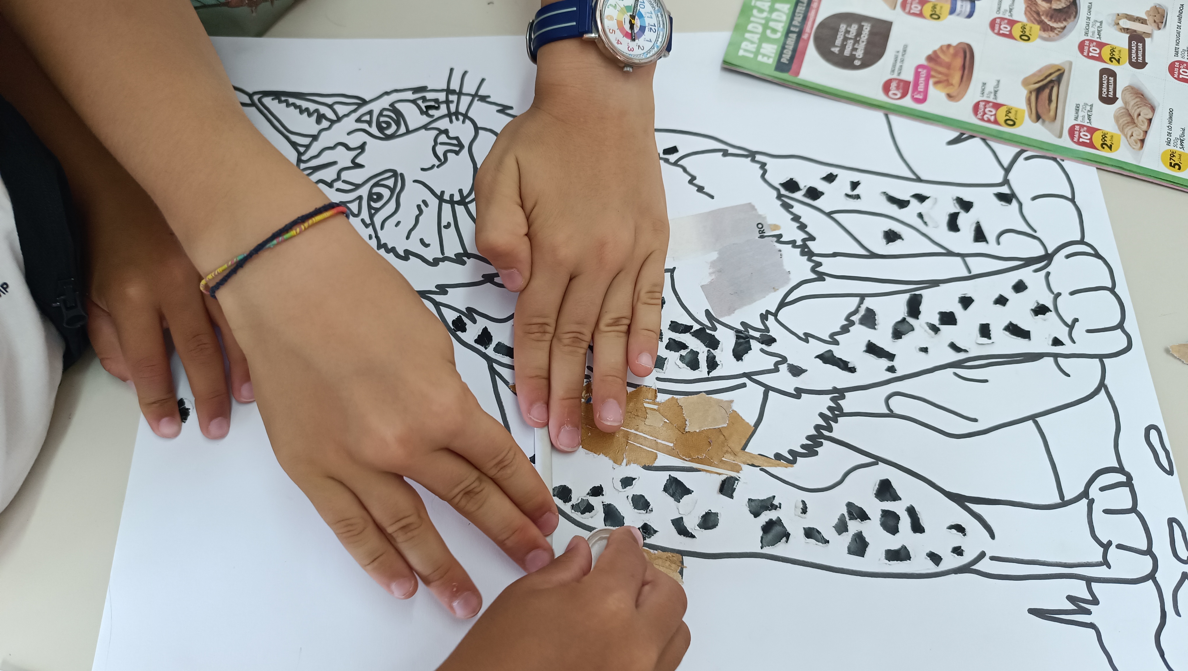 Alunos focados na colagem de pedacinhos de papel com a cola amiga do ambiente UHU ReNature, dando vida e textura ao pelo do lince.